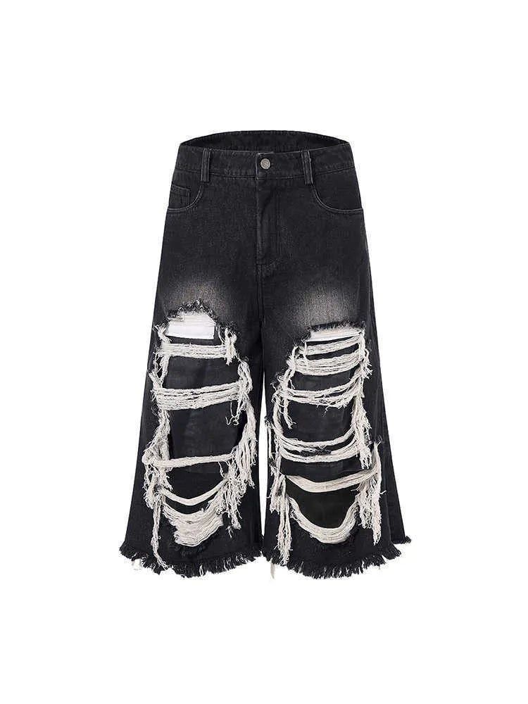 Model wearing black cropped wide-leg jeans with a distressed patch detail on the leg.