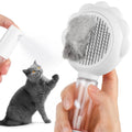 Grey spray cat brush with release button and stainless steel bristles for pet grooming.