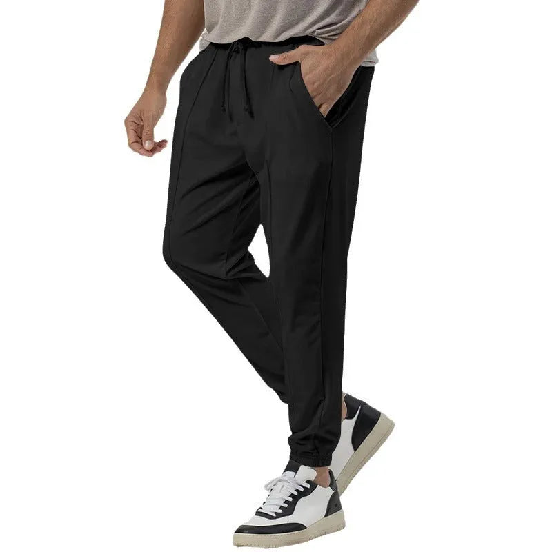Men's grey loose tapered casual track sweatpants with a straight leg and elastic waistband.