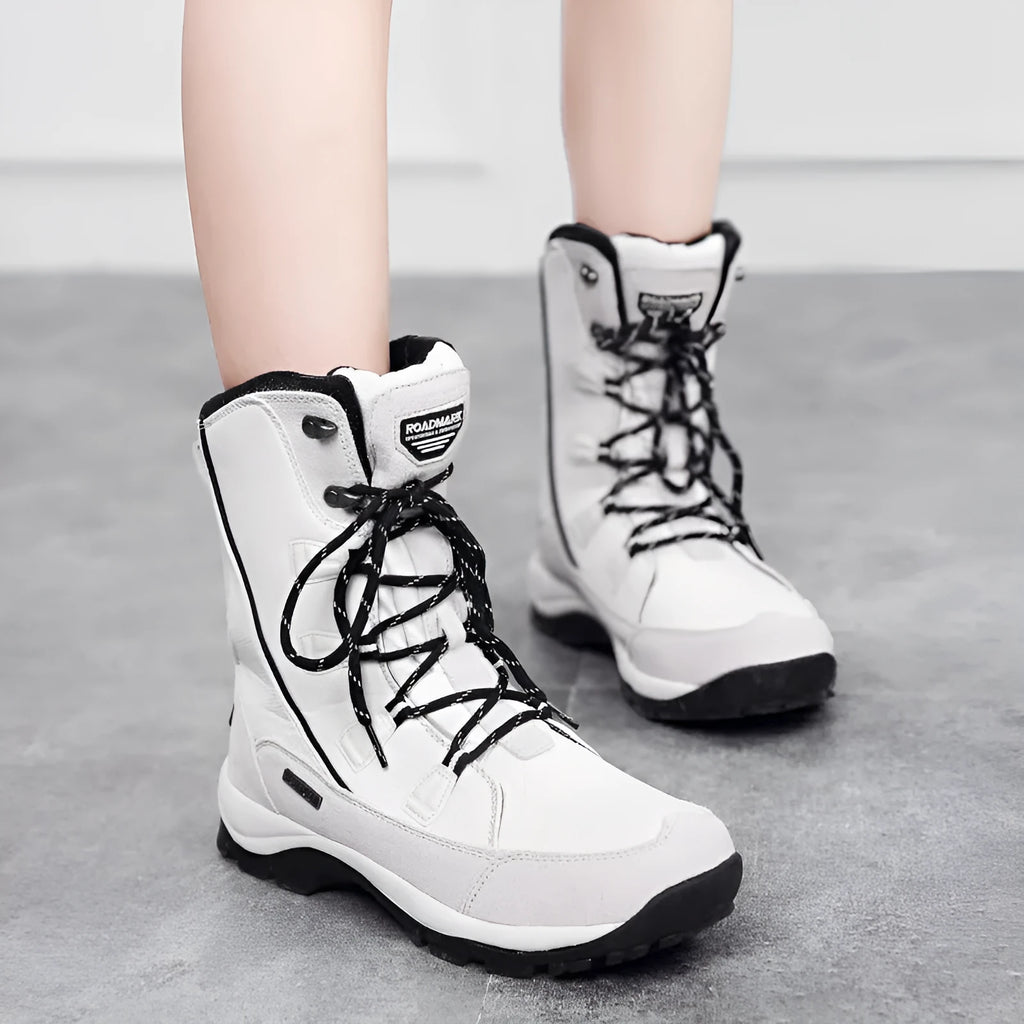 Women's black genuine leather mid-calf snow boots with round toe and thick rubber sole on a white background.