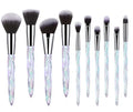 10 clear crystal handle foundation brushes with diamond shanks, showing black, blue, red, and yellow colour options.