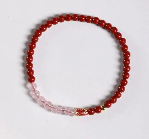 Hand-woven purple gold sand and strawberry quartz koi bracelet with crystal and pearl beads on a light background.