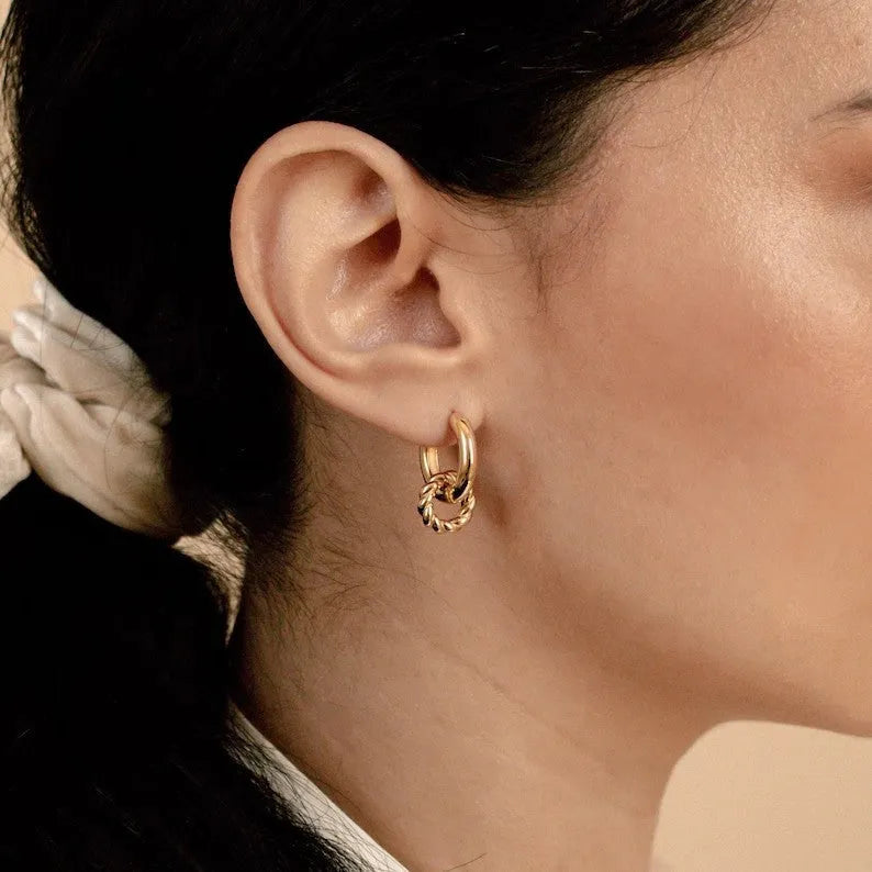 Double ring twist geometric square ear clip simple copper earrings on a neutral background