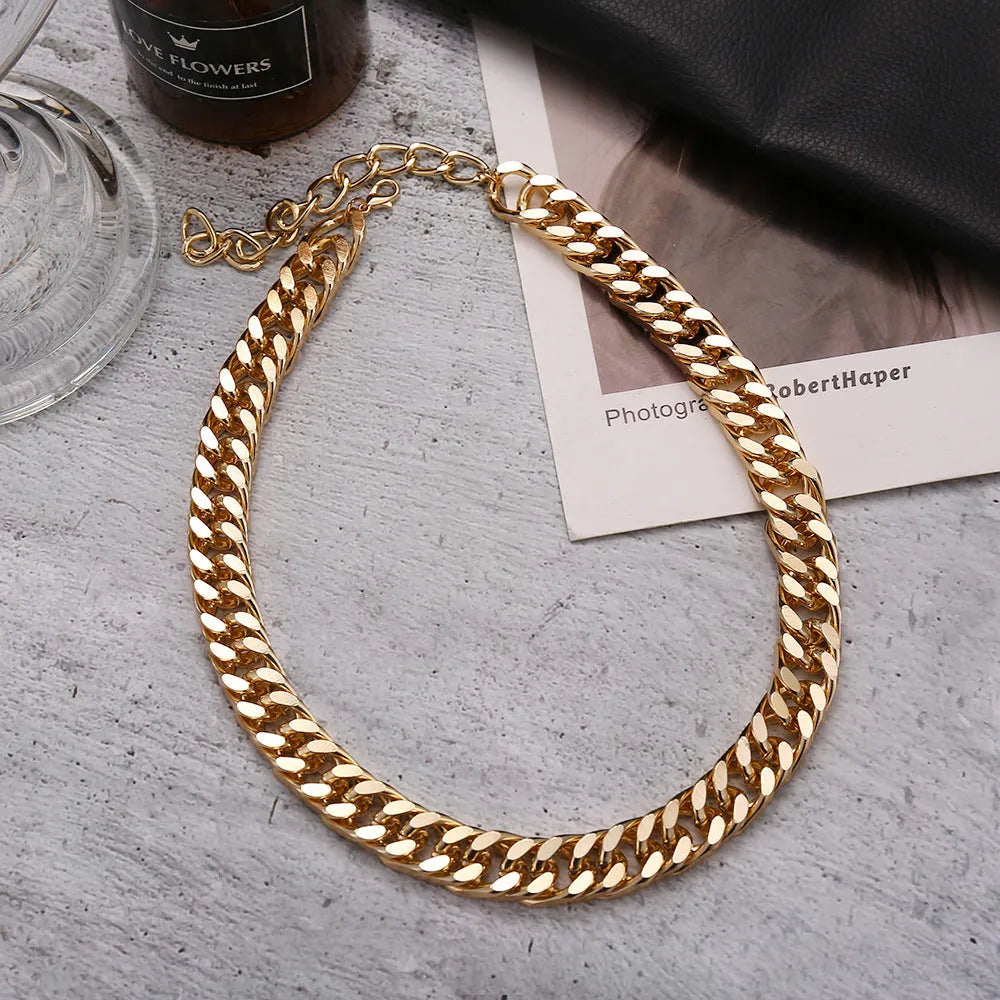 Women's gold tone thick chain necklace with a pendant on a white background.