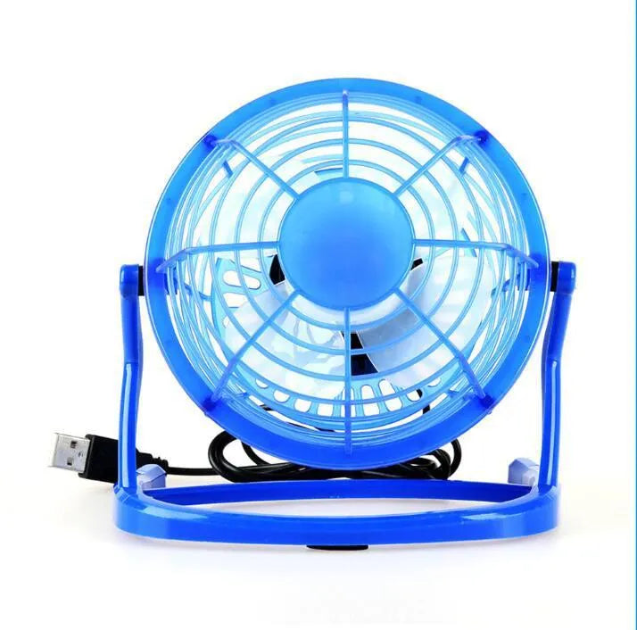 Black mini USB desk fan with adjustable angle on a wooden desk.