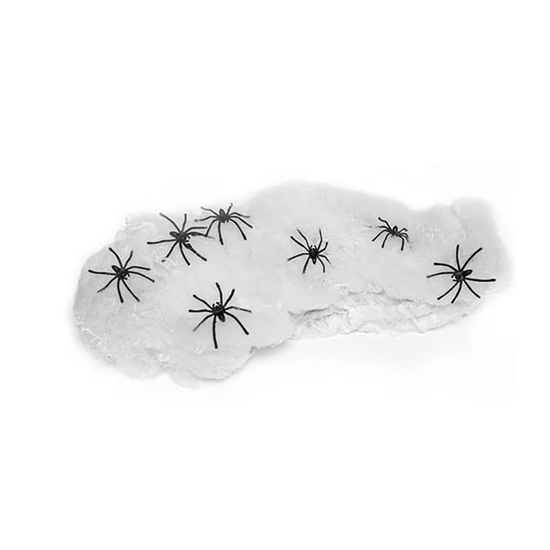 Halloween cotton spider web decoration with white plastic spiders on a dark background