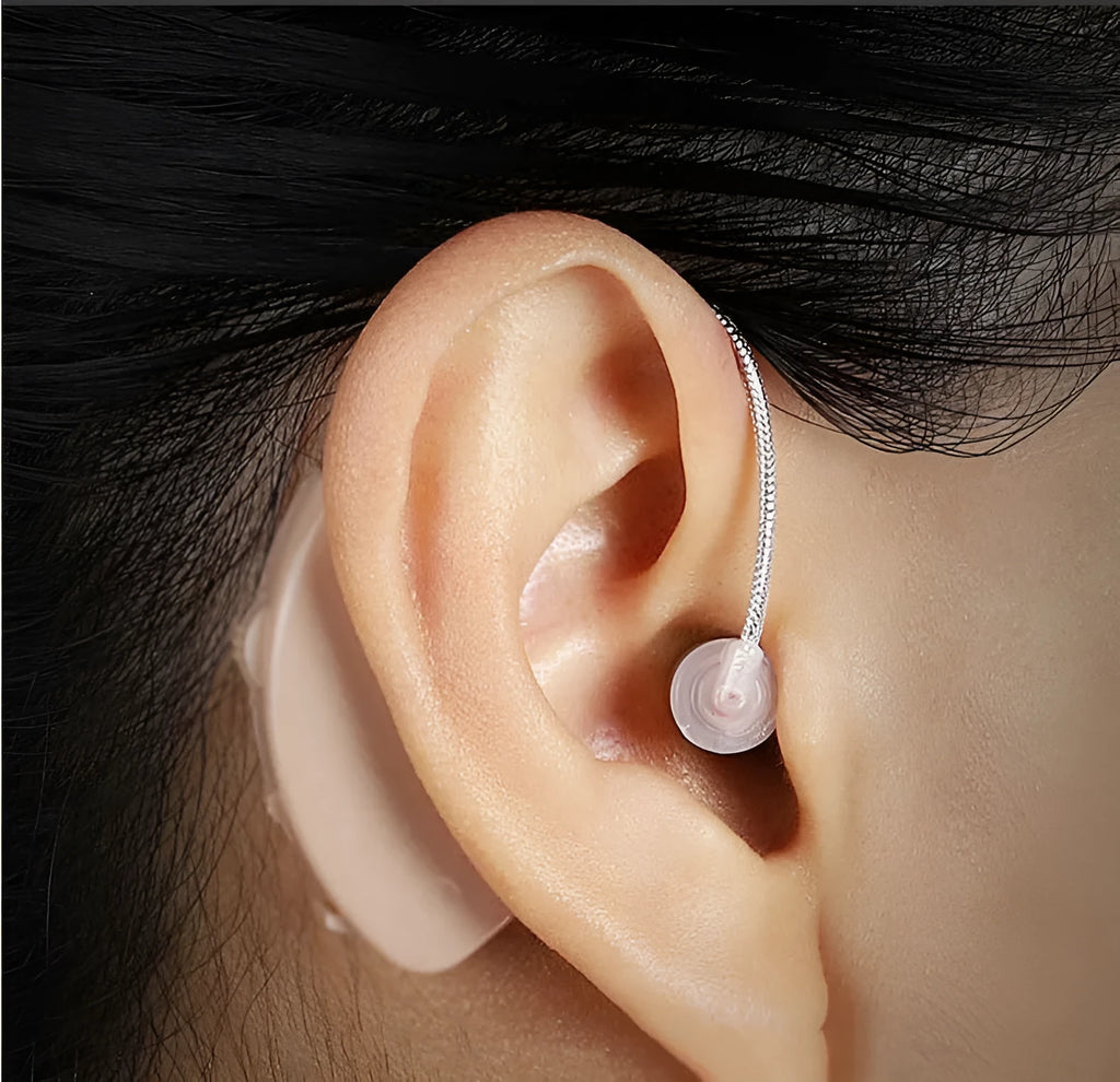 Black rechargeable hearing aid amplifier with silicone earplugs and a USB charging cable.