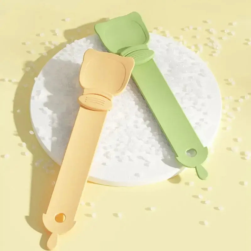 Cat Treat Spoon in green, orange, and white, measuring 27 x 6.5 cm, designed for scooping and serving cat strips