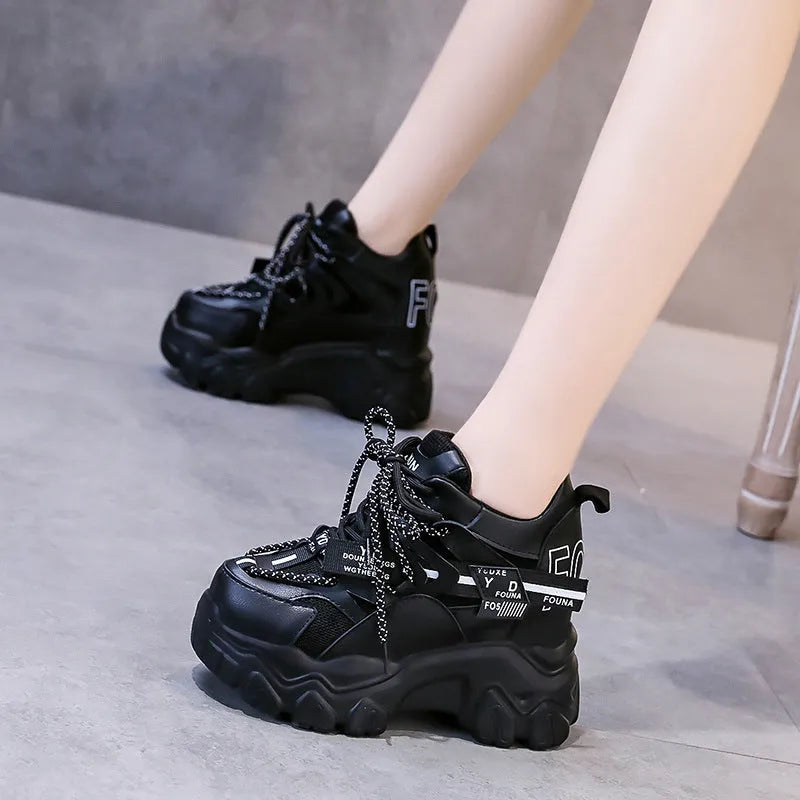 Women's white and black platform tennis shoes with mesh upper and cross-strap.