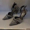 Women's black high-heeled shoes with a red sole, showing stiletto heel and pointed toe design.