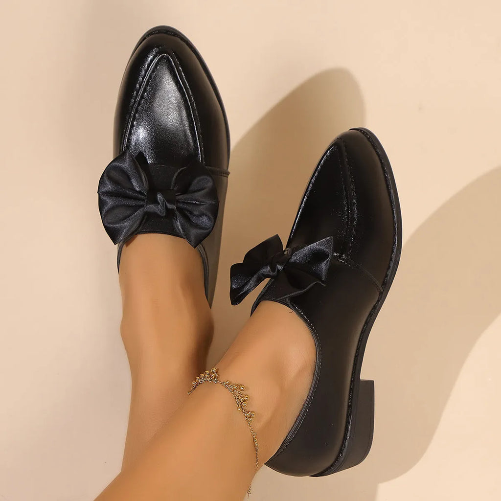 Women's pointed-toe PU slip-on shoe with a decorative bow on a rubber sole.