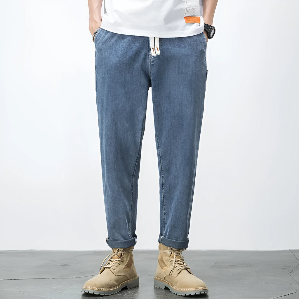 Men's loose plus size elastic waist jeans in blue cotton denim with mid waist straight leg fit