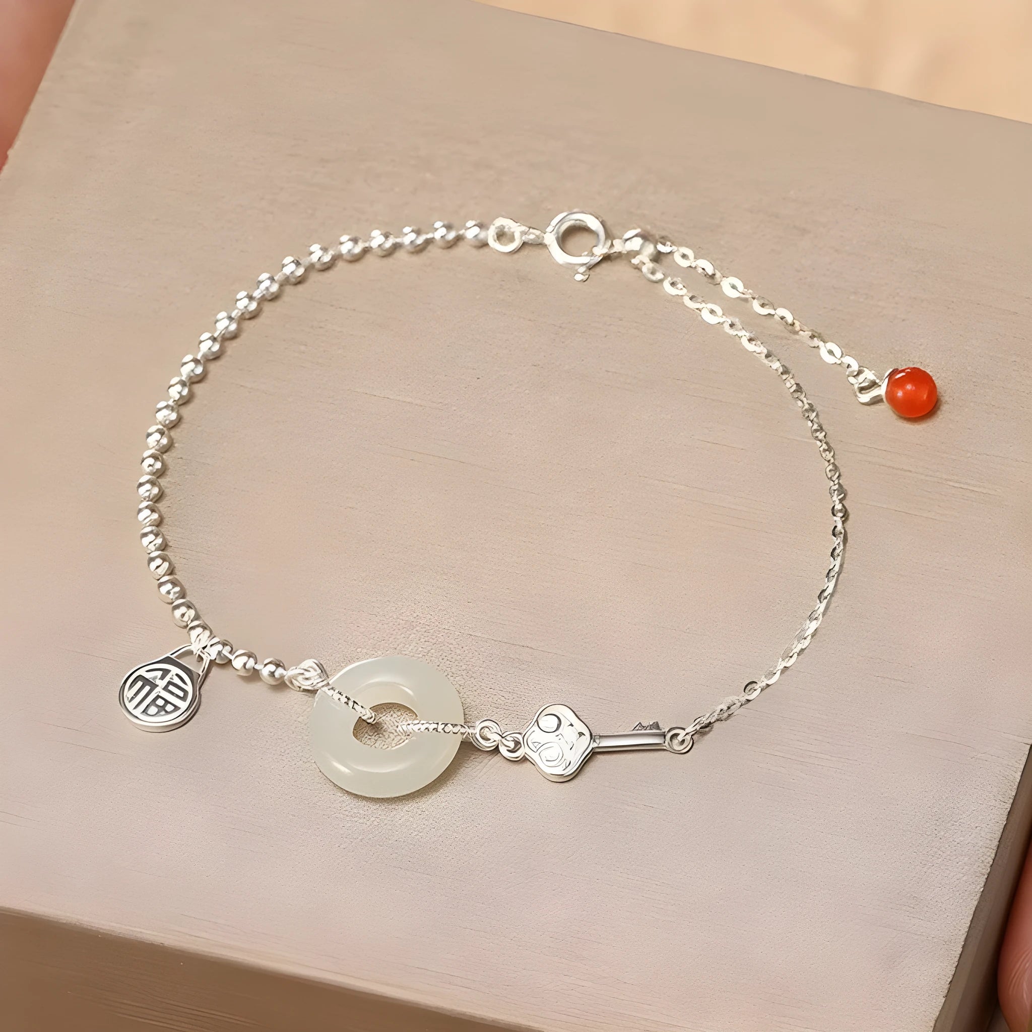 Women's Chinese style silver bracelet with a Hetian jade stone and intricate Peace Buckle design.