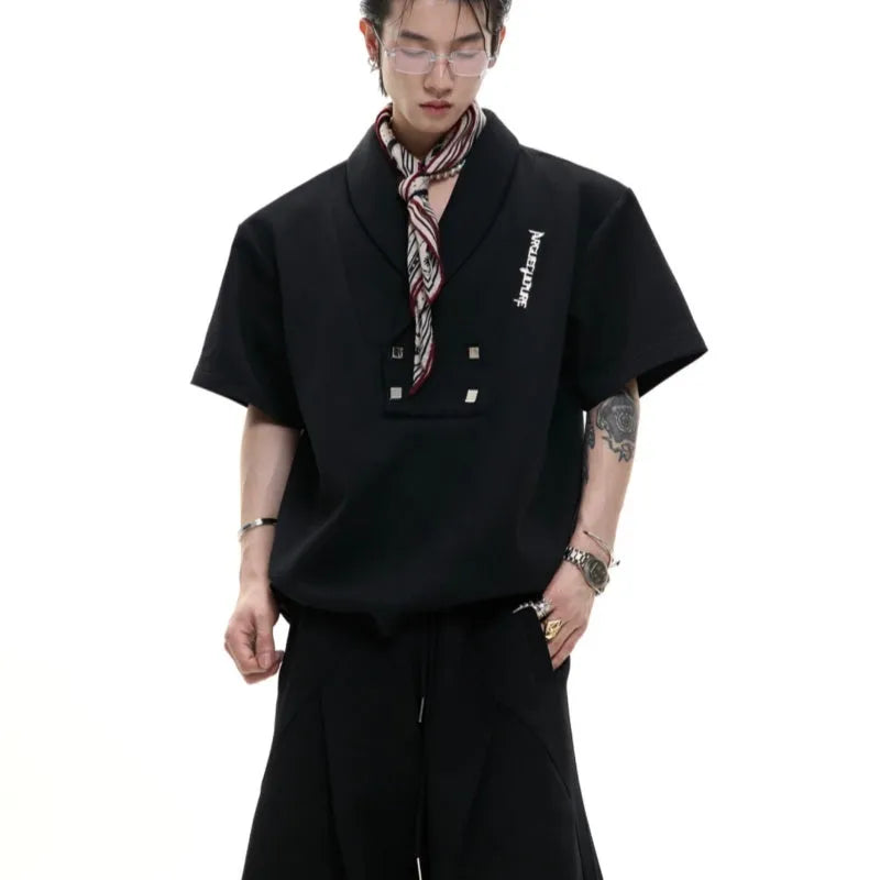 Men's dark grey cotton sports suit with V-neck jacket, padded shoulders, metal embellishments, and matching shorts.