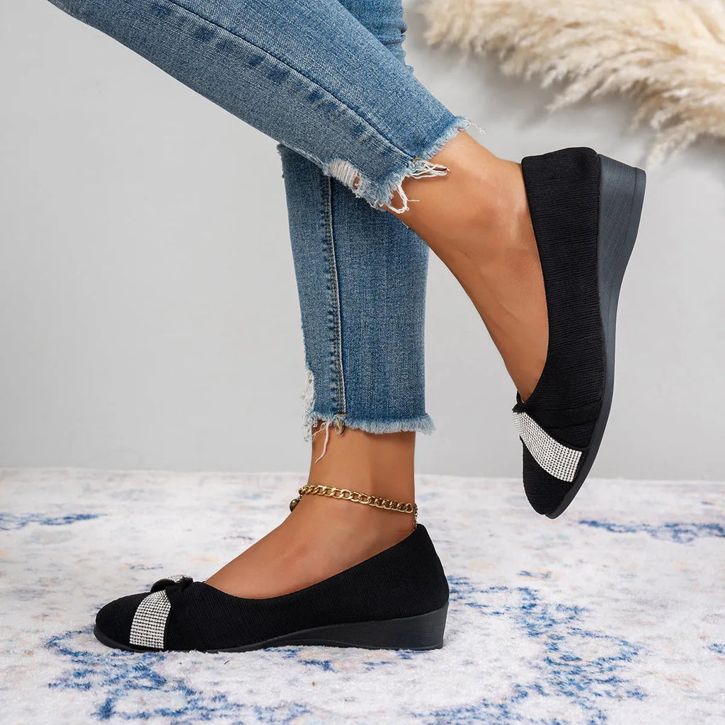 Women's black low-cut slip-on casual shoes with rhinestone detail and a short chunky heel.