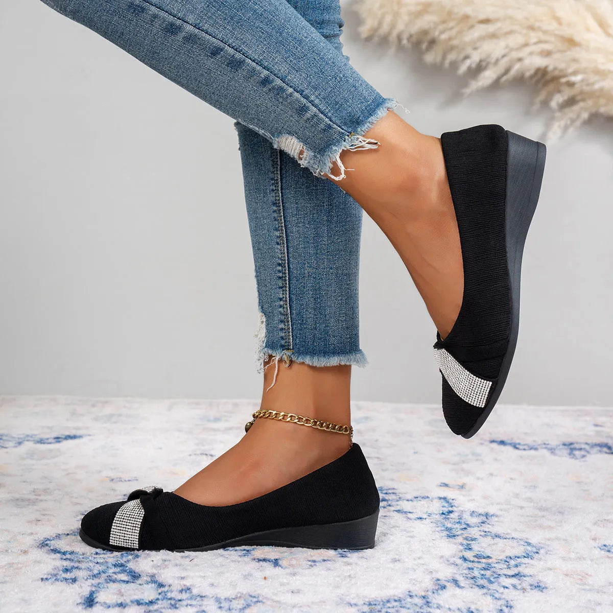 Women's black low-cut slip-on casual shoes with rhinestone detail and a short chunky heel.