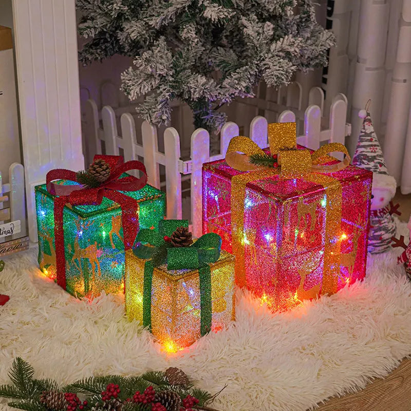 Set of three pre-lit Christmas gift box decorations with bows and LED lights for outdoor use.