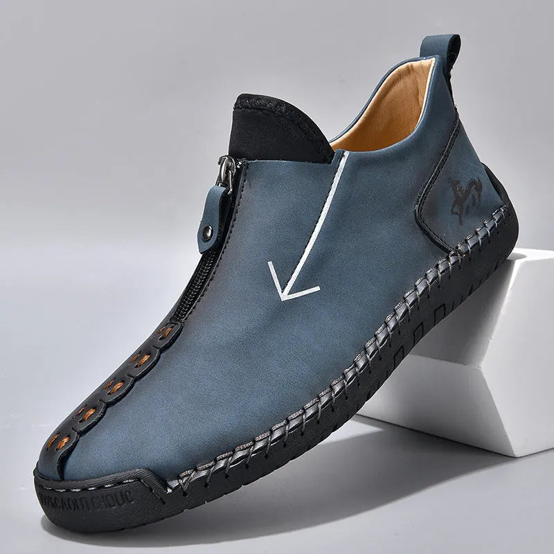 Men's brown leather-look zip-up ankle boots with hand-stitched detailing on a white background.