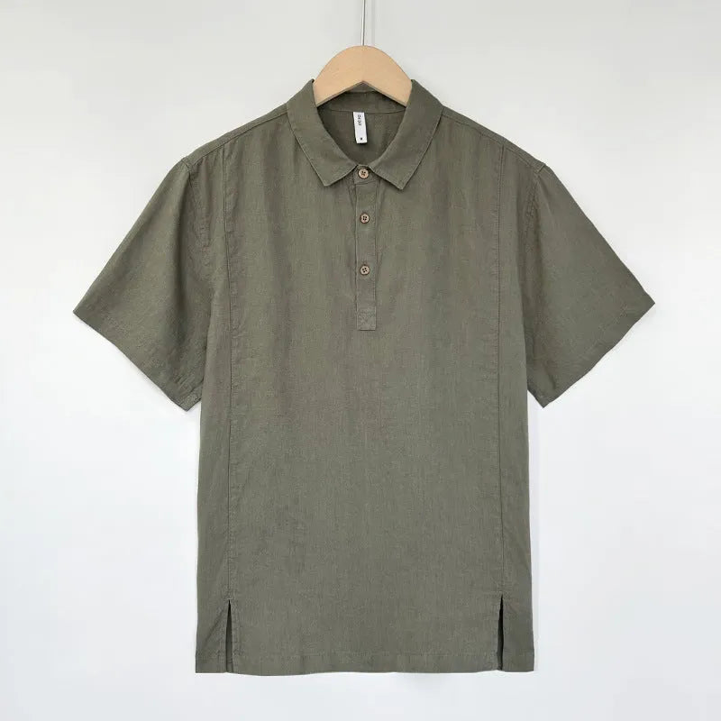 A man's loose-fit linen short-sleeve top in grey green with a V-neck and thin lapels, laid flat.