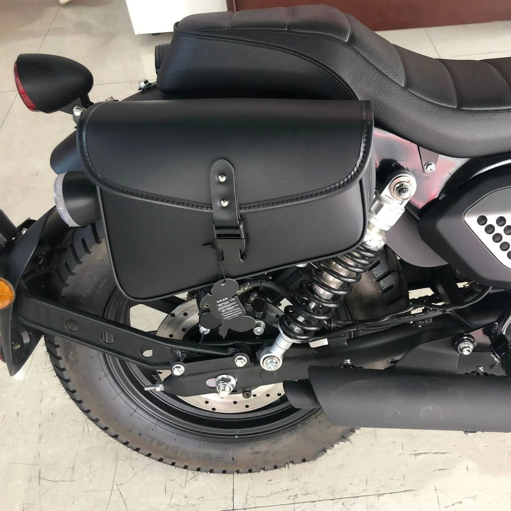 Black motorcycle swingarm saddlebag mounted on a Sportster, showing its size and side-mounting position.
