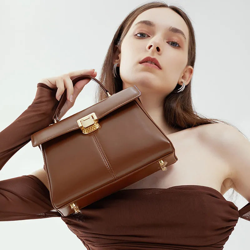 Black genuine leather women's shoulder bag with a vachette clasp, shown open to reveal a zippered hidden pocket.