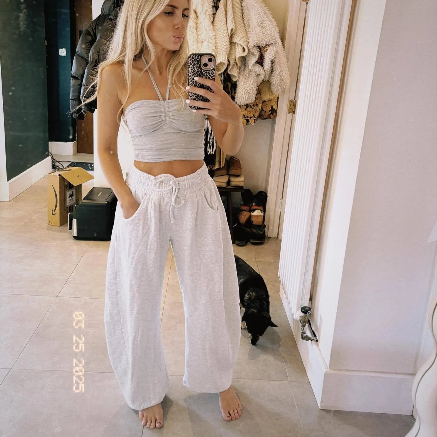 Women's loose cropped sweatpants with elastic drawstring waist in apricot colour showing side pockets and street fashion styling
