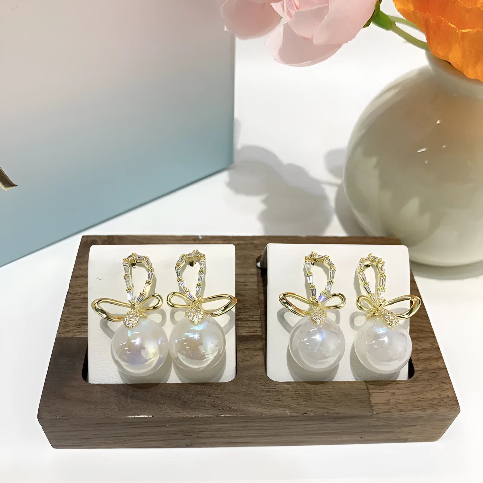 Pair of minimally designed gold tone drop earrings with single faux pearl