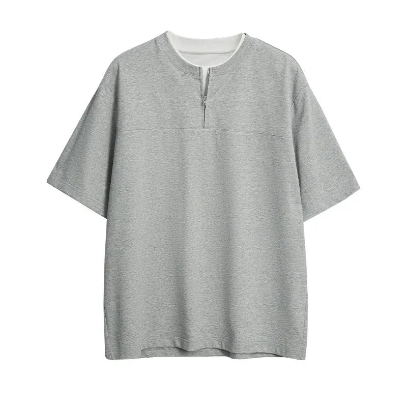 Women's loose blue patchwork top with false two-piece design on a hanger.