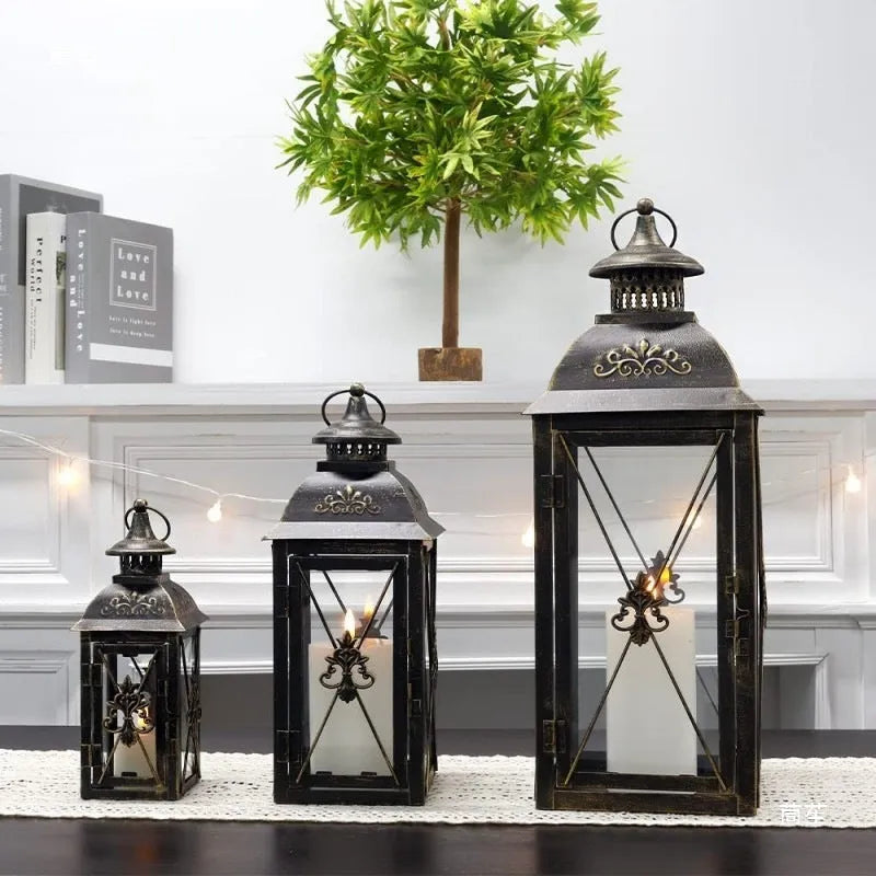 Black and white wrought iron floor storm lantern with tempered glass panels for courtyard decoration.