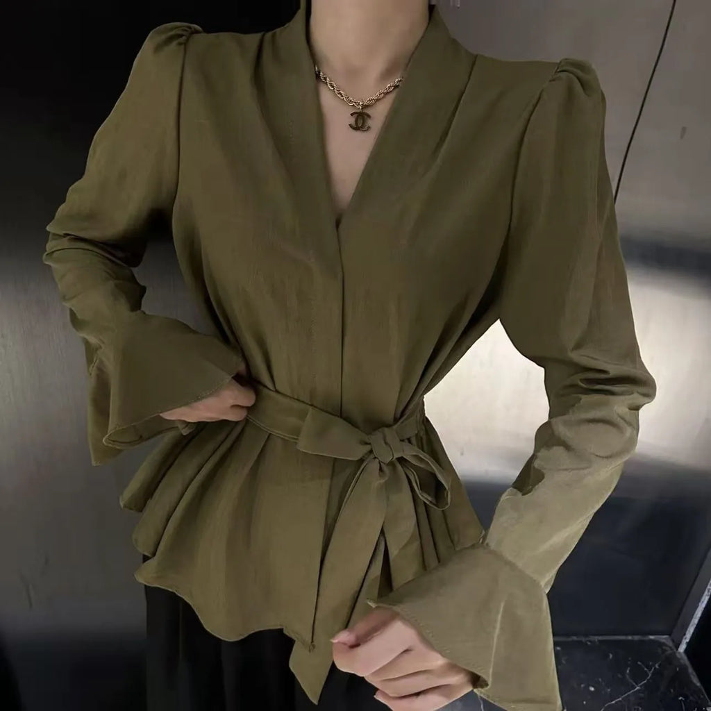 Women's black shirt with an irregular collar and long bell sleeves on a model.