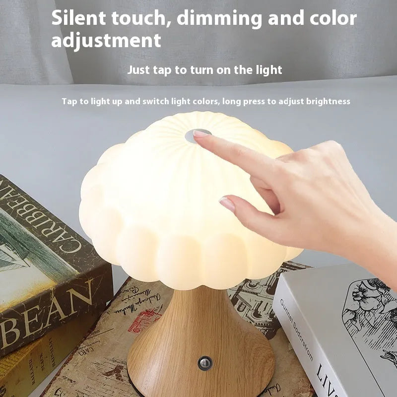 Small mushroom-shaped night lamp on a charging base in wood grain colour finish.