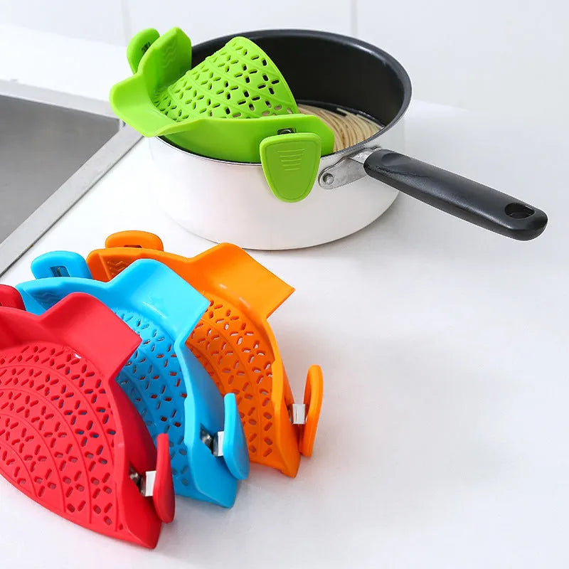 Green silicone pot side drain stopper kitchen gadget with stainless steel on wooden surface