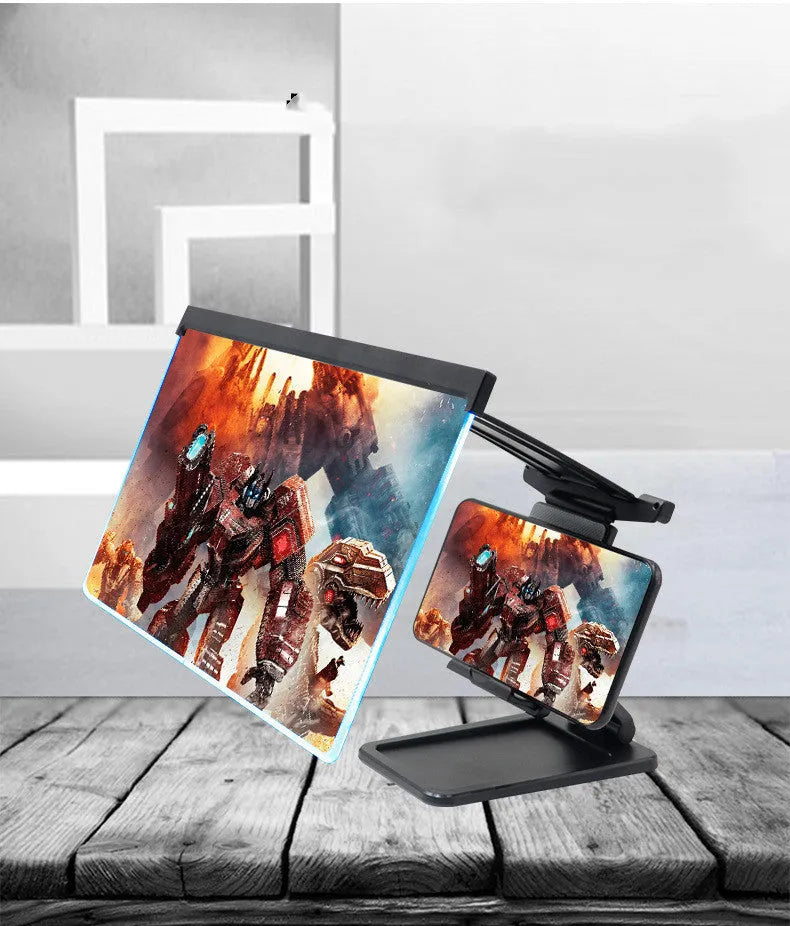 Black detachable mobile phone screen magnifier and holder set up on a desk, showing a phone displaying a magnified movie scene.