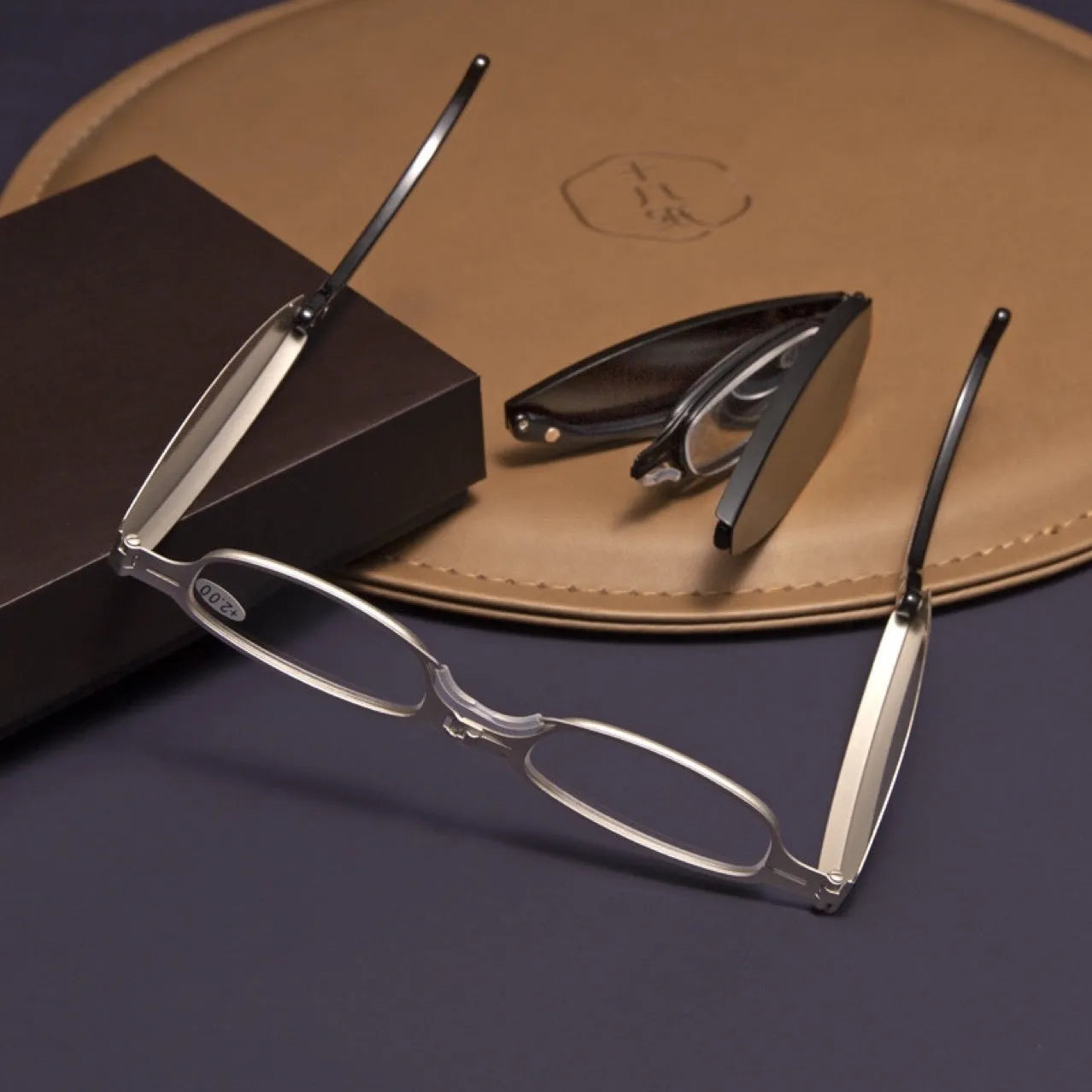 Black folding presbyopic glasses shown open and folded, with retro ring-style frame.