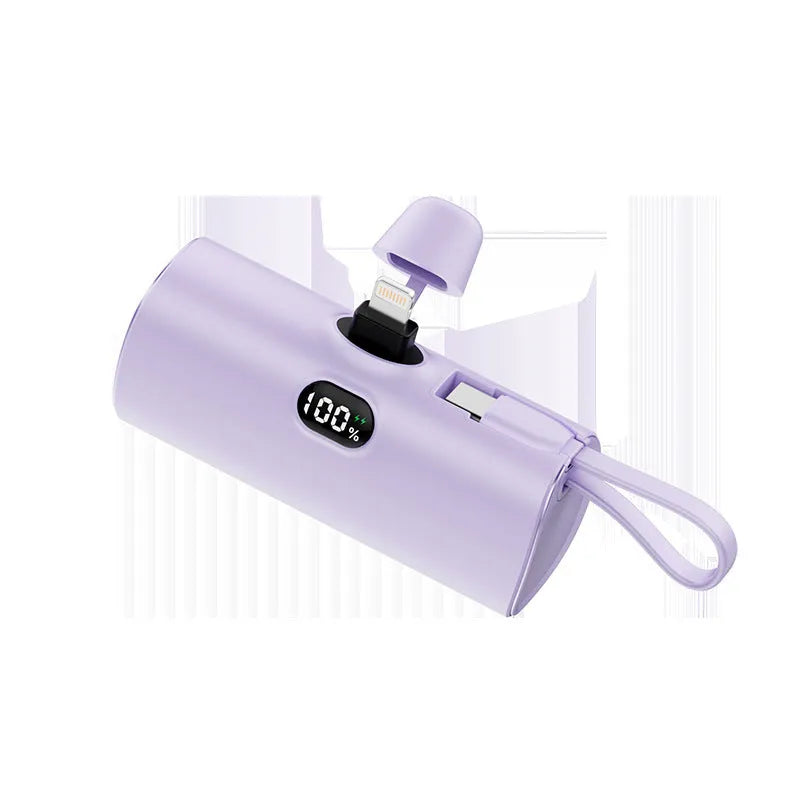 Compact capsule-shaped wireless power bank with a UK plug and digital display, shown in pink.