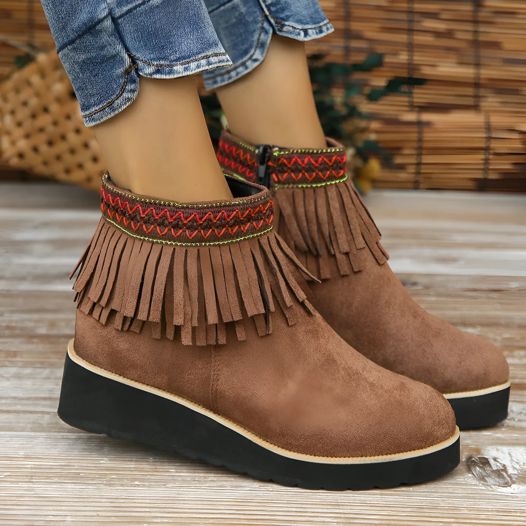 Women's dark brown suede ankle boots with a thick wedge sole, side zip, and decorative tassel.