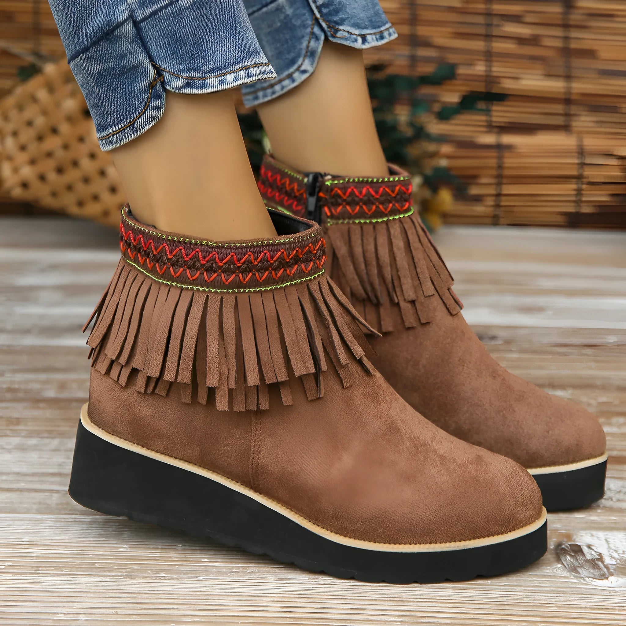 Women's dark brown suede ankle boots with a thick wedge sole, side zip, and decorative tassel.