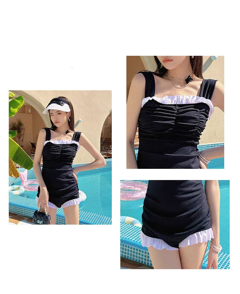 Women's solid pink one-piece swimsuit with black suspender straps on a mannequin.