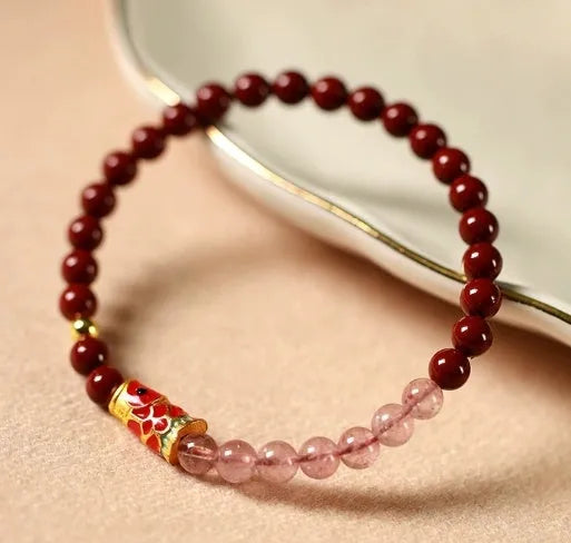 Hand-woven purple gold sand and strawberry quartz koi bracelet with crystal and pearl beads on a light background.