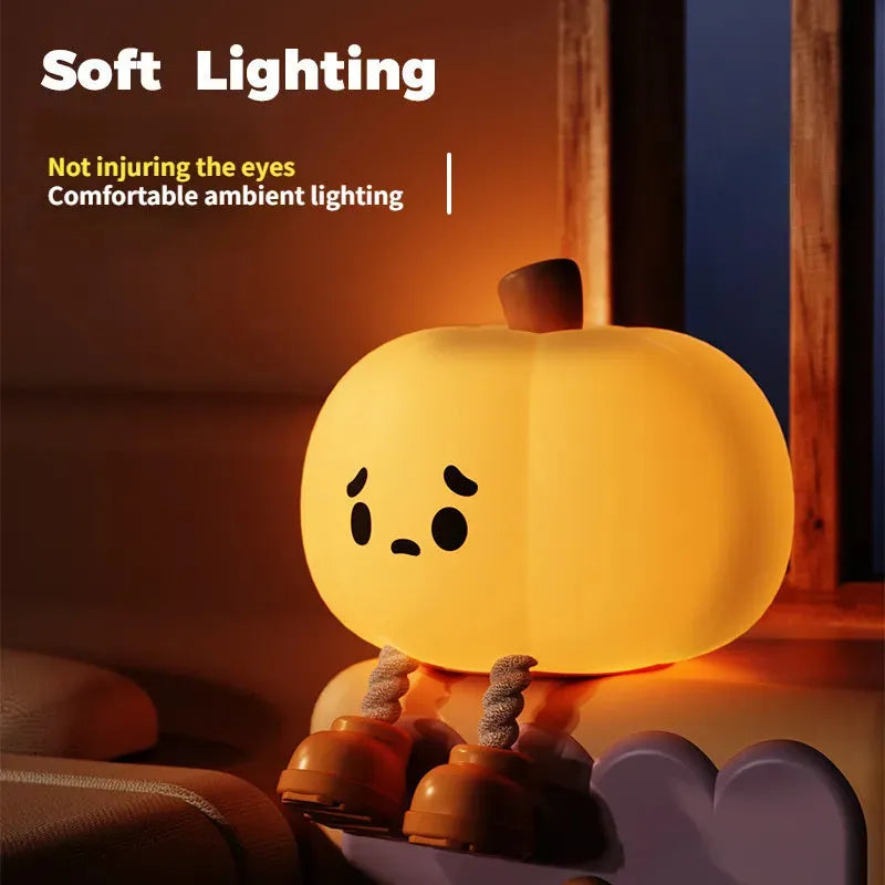 Soft orange silicone pumpkin-shaped night light with a warm glowing face on a table.