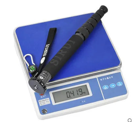 Black carbon fibre telescopic camera monopod fully extended next to a DSLR.