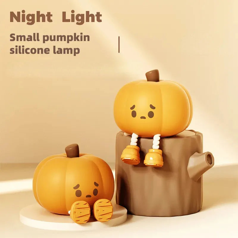 Soft orange silicone pumpkin-shaped night light with a warm glowing face on a table.