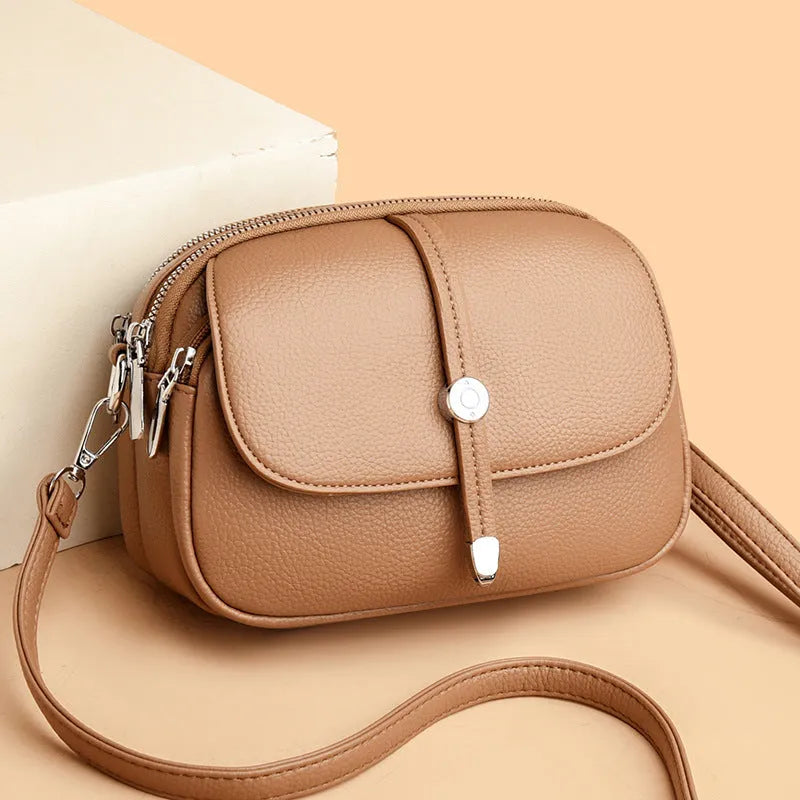 Women's soft PU leather crossbody shoulder bag in oval suitcase shape, shown in black colour with decorative sewing thread detailing.