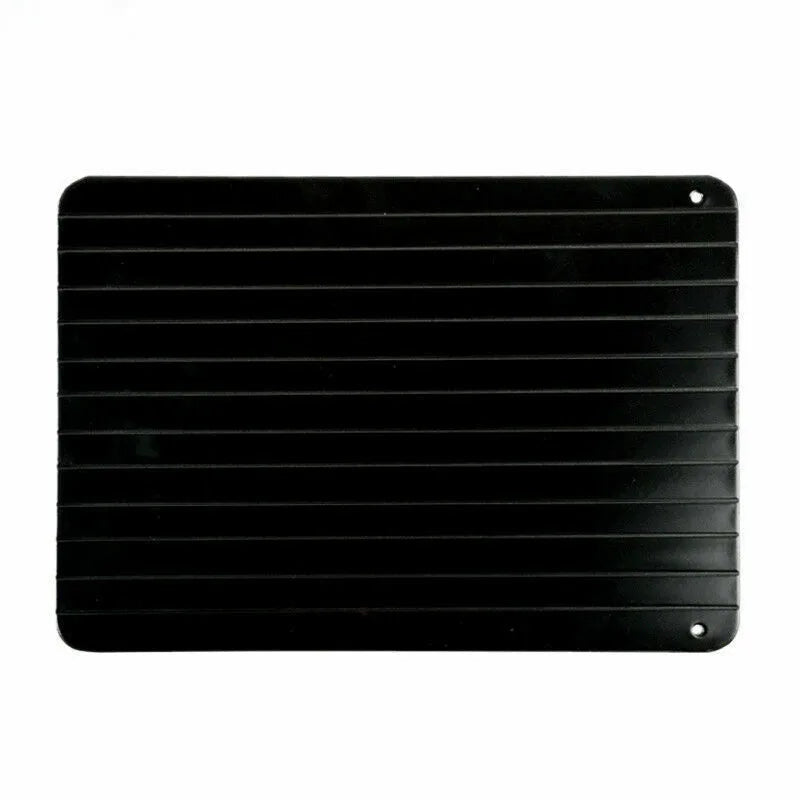 Black rectangular aluminium fast defrost tray for thawing frozen food on a kitchen counter.