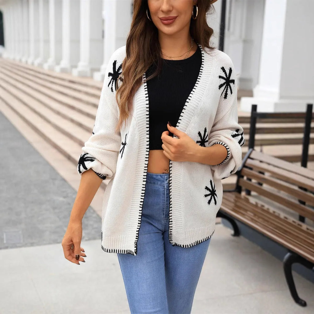 Beige Jacquard floral pattern knitted coat on a hanger, showing loose cardigan style and regular sleeves.