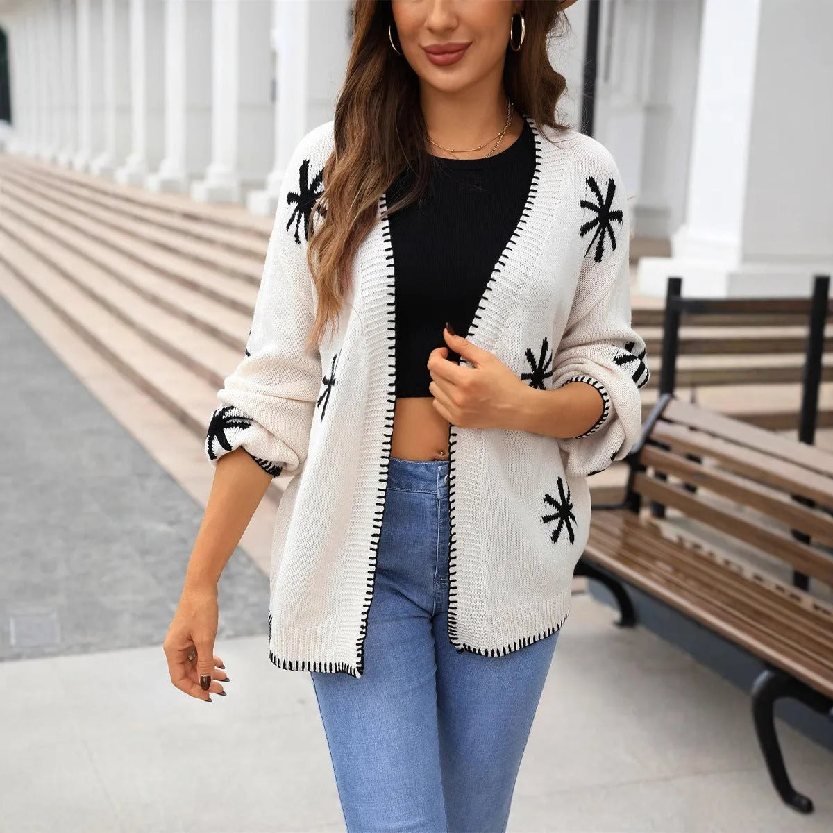 Beige Jacquard floral pattern knitted coat on a hanger, showing loose cardigan style and regular sleeves.