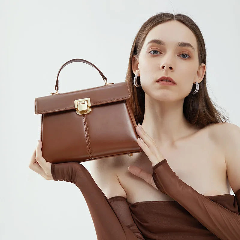 Black genuine leather women's shoulder bag with a vachette clasp, shown open to reveal a zippered hidden pocket.