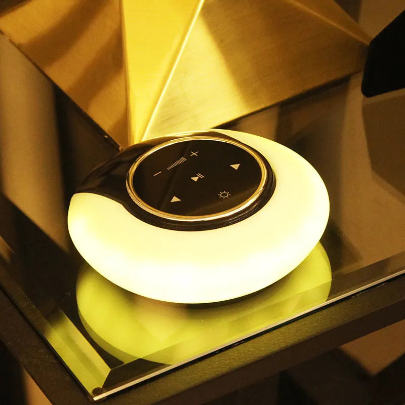 Blue and white Bluetooth speaker desk lamp with folded head on a wooden table, showing touch panel.