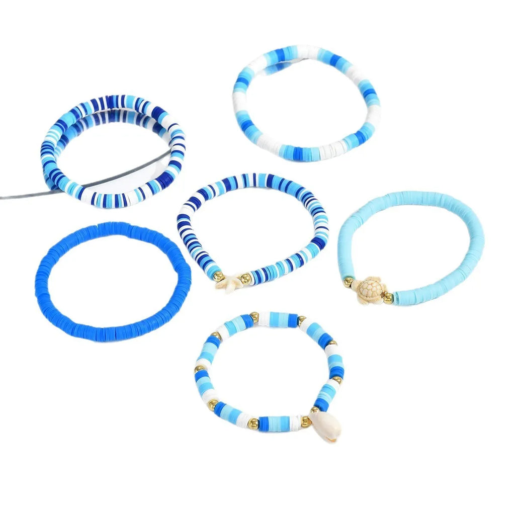 Six Bohemian blue polymer clay bracelets with geometric shell designs arranged as a set