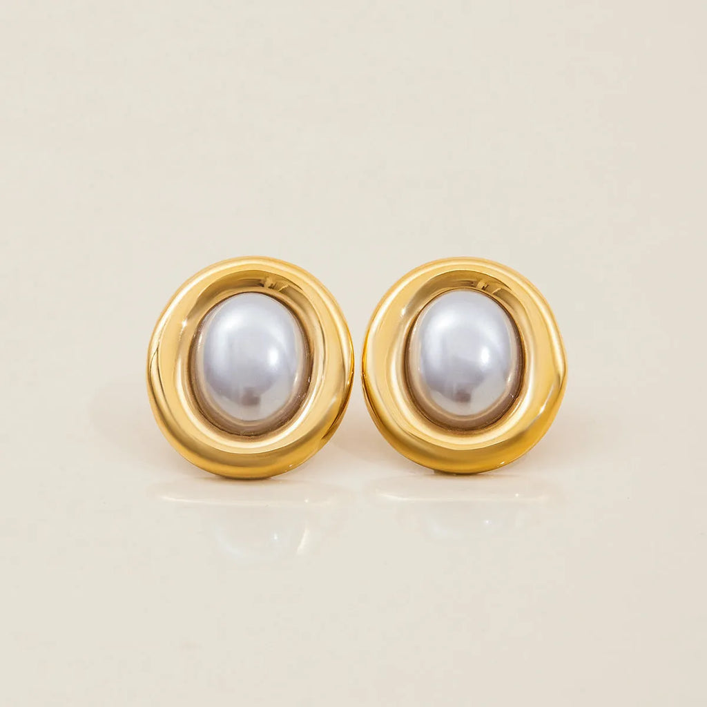 Small vintage-style pearl ear studs with a gold-tone finish on a stainless steel post.